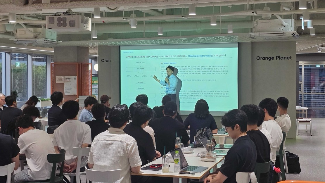 개발자 밋업 무대 중앙에서 발표하는 모습 — 본인 슬라이드가 크게 보인다